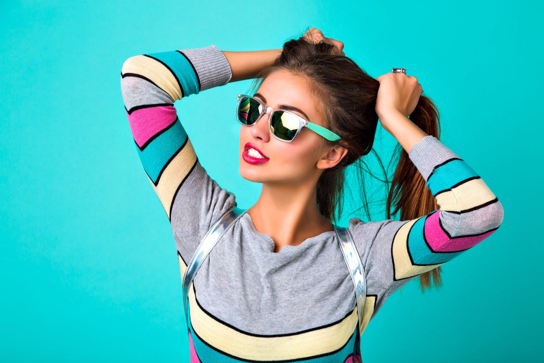 Mujer con gafas de sol sobre fondo turquesa para artículo de Academia CLIO